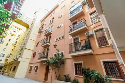 a pink building with balconies on a street at Charming apt by the beach with stunning harbor views in Port Saplaya