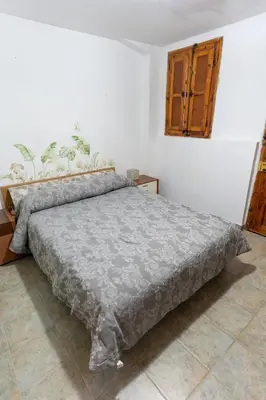 a bedroom with a bed with a gray blanket at La Replaceta in Segorbe