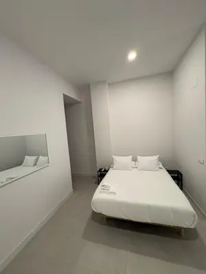 a white bedroom with a bed and a mirror at Centric Loft near Arts & Science in Valencia