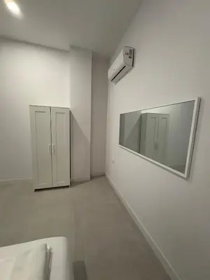 a white bathroom with a mirror and a sink at Centric Loft near Arts & Science in Valencia