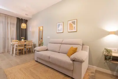 a living room with a couch and a dining room at Paradise Suite - Cómodo y acogedor - Conectado con Aeropuerto, Playa y Centro in Valencia
