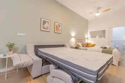 a bedroom with a bed and a couch at Paradise Suite - Cómodo y acogedor - Conectado con Aeropuerto, Playa y Centro in Valencia