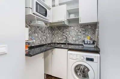a small kitchen with a washer and dryer at Precioso estudio en la playa norte de Valencia in Puebla de Farnals