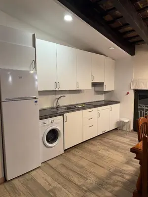 a kitchen with white cabinets and a washer and dryer at Miguelete tower & 4th FLOOR & City center and no elevator in Valencia