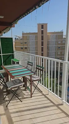 a table and chairs on a balcony with a view of buildings at Coqueto apartamento en la playa in Puebla de Farnals
