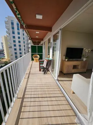 a balcony with a couch and a tv on it at Coqueto apartamento en la playa in Puebla de Farnals
