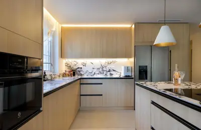 a kitchen with wooden cabinets and a black refrigerator at Casa Roka in Alberique