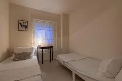 a room with two beds and a window and a table at Casa Roka in Alberique