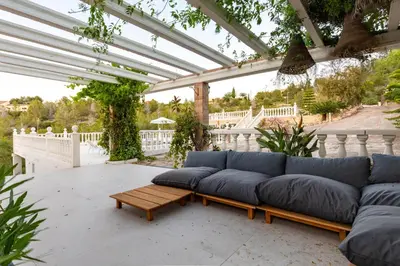 a couch sitting on a patio under a pergola at Casa Roka in Alberique