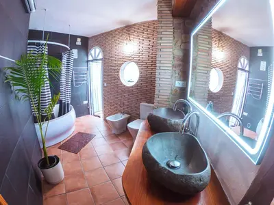 a bathroom with two sinks and two toilets at Casa de piedra en el casco antiguo de Sagunto in Sagunto
