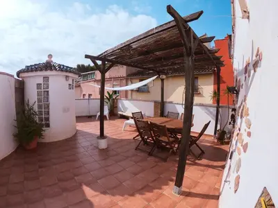 a patio with a wooden table and chairs at Casa de piedra en el casco antiguo de Sagunto in Sagunto