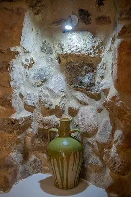 a green vase sitting in front of a stone wall at Casa de piedra en el casco antiguo de Sagunto in Sagunto
