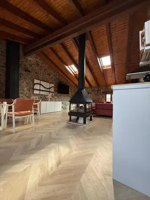 a living room with a wood stove in the middle at Hotel Rural Los Abriles in El Toro