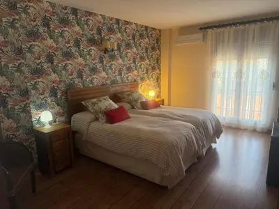 a bedroom with a large bed with floral wallpaper at Hotel Rural Los Abriles in El Toro