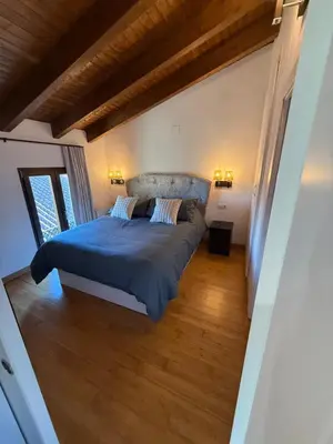 a bedroom with a bed with a blue comforter at Hotel Rural Los Abriles in El Toro
