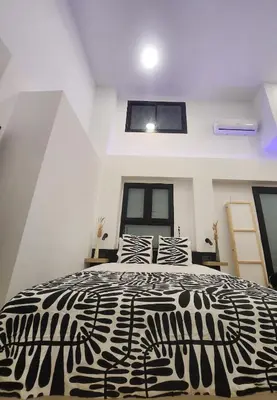 a black and white bed in a room with windows at kala-mar Valencia in Valencia