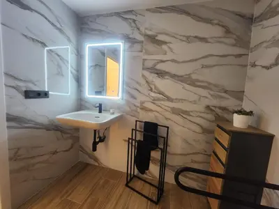 a bathroom with a sink and a stone wall at kala-mar Valencia in Valencia