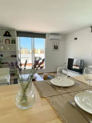 a table with glasses and a vase of flowers on it at More then a loft in Godella