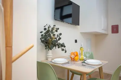 a dining room table with a vase of flowers on it at Nomad Haux Mestalla Apartments in Valencia