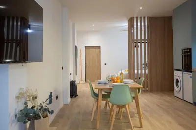 a kitchen and dining room with a table and chairs at Nomad Haux Mestalla Apartments in Valencia