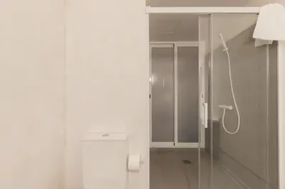 a white bathroom with a shower and a toilet at Chic & Cozy Stay in Valencia in Valencia