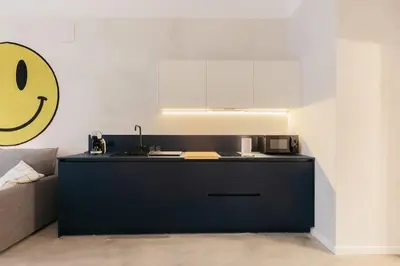 a kitchen with a black counter with a smiley face on the wall at Chic & Cozy Stay in Valencia in Valencia