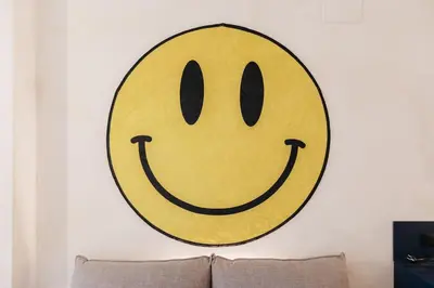 a yellow smiley face on a wall above a couch at Chic & Cozy Stay in Valencia in Valencia