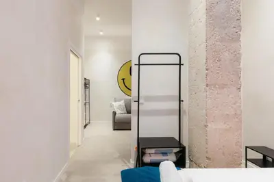 a living room with white walls and a blue couch at Trendy Retreat in Valencia in Valencia