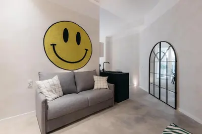 a living room with a couch with a smiley face on the wall at Trendy Retreat in Valencia in Valencia