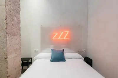 a bedroom with a bed with a neon sign on the wall at Trendy Retreat in Valencia in Valencia