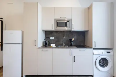 a white kitchen with a sink and a microwave at Les Arts Turia by Concept Flats in Valencia