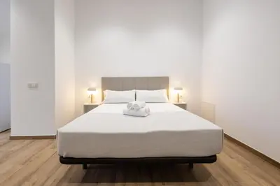a white bed with a towel on top of it at Les Arts Turia by Concept Flats in Valencia