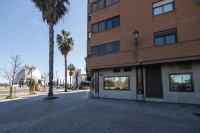 a brick building with a palm tree next to a street at Les Arts Turia by Concept Flats in Valencia