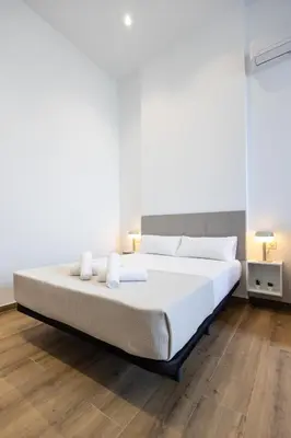 a bedroom with a large bed with white sheets at Les Arts Plaza by Concept Flats in Valencia