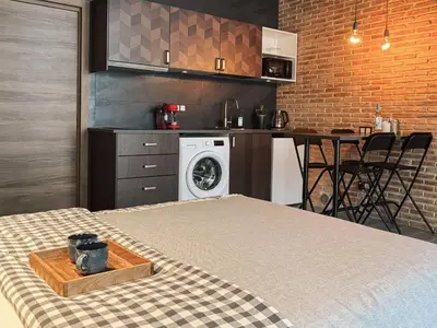 a room with a bed and a kitchen with a washing machine at New Loft Rusafa in Valencia