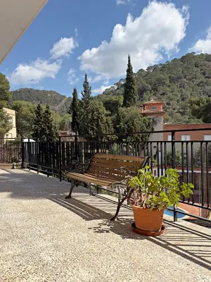 a wooden bench sitting on a balcony with a plant at Cau de Serra 