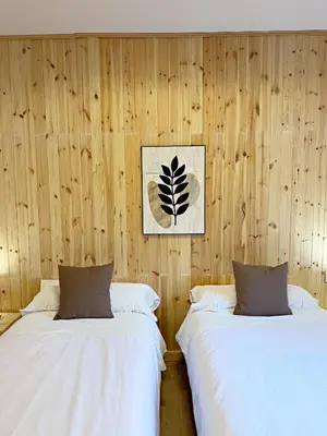 two beds in a room with wooden walls at Cau de Serra 