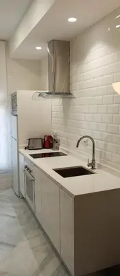 a white kitchen with a sink and a refrigerator at Apartamentos PADRE LUIS in Valencia