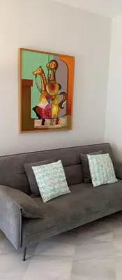 a couch in a living room with a painting on the wall at Apartamentos PADRE LUIS in Valencia