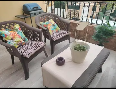 a patio with two chairs and a table with a plant at Casa con Barbacoa en Urbanización Privada in Valencia