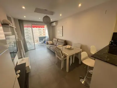 a kitchen and a living room with a table and a couch at Paradise Cullera in Cullera