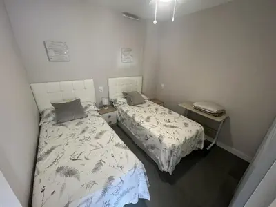 a bedroom with two beds and a phone in it at Paradise Cullera in Cullera