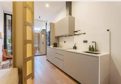 a kitchen with white cabinets and a large window at Mestalla flats & Rut in Valencia