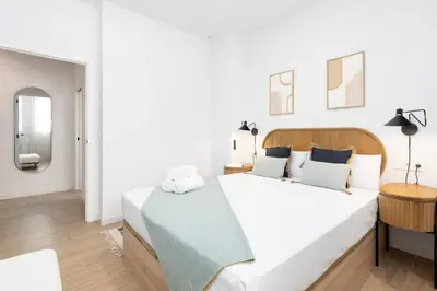 a white bedroom with a large bed and a mirror at Travel Habitat Peset Aleixandre Apartments in Valencia