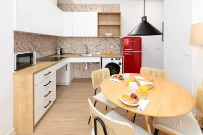 a kitchen with a wooden table and a red refrigerator at Travel Habitat Peset Aleixandre Apartments in Valencia