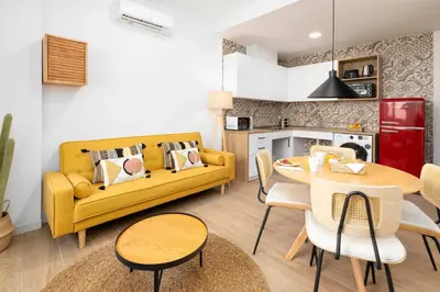 a living room with a yellow couch and a table at Travel Habitat Peset Aleixandre Apartments in Valencia