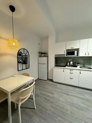 a kitchen with white cabinets and a table at Cozy apartment Valencia in Valencia