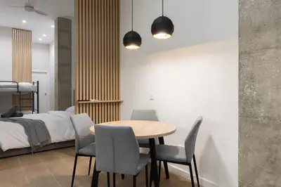 a bedroom with a table and chairs and a bed at Luxury Apartments Oceanografic in Valencia