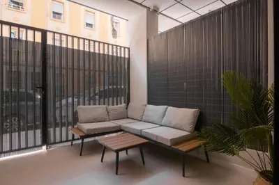 a couch and a table on a balcony at Luxury Apartments Oceanografic in Valencia