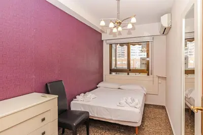 a small bedroom with a bed and a chair at GuestReady - Delightful Valencia Retreat in Valencia